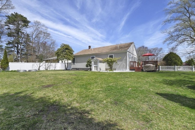 view of side of property featuring a storage shed, a deck, fence, an outdoor structure, and a yard