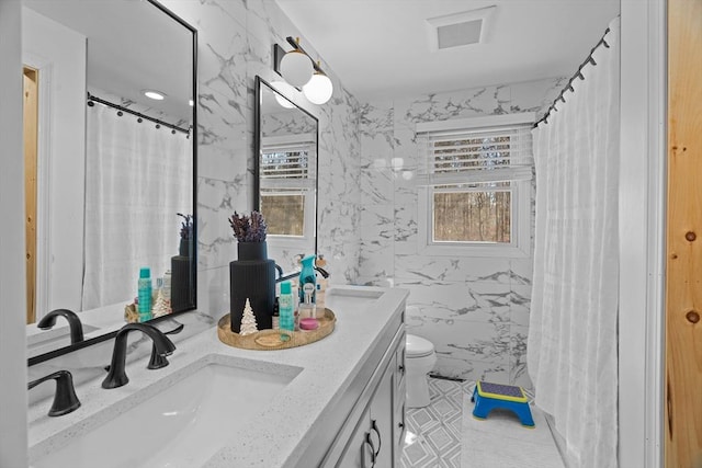 bathroom with tile walls, visible vents, toilet, and vanity