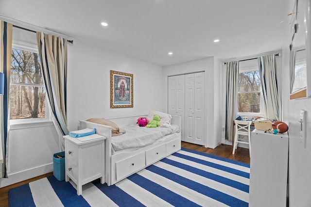 bedroom featuring a closet, recessed lighting, baseboards, and wood finished floors