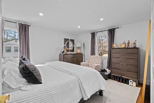 bedroom with multiple windows, wood finished floors, and recessed lighting