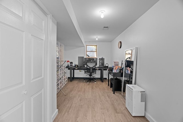 home office featuring visible vents, light wood-style flooring, and baseboards