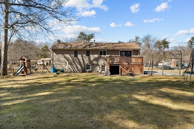 rear view of property featuring fence, a yard, stairs, a playground, and a trampoline