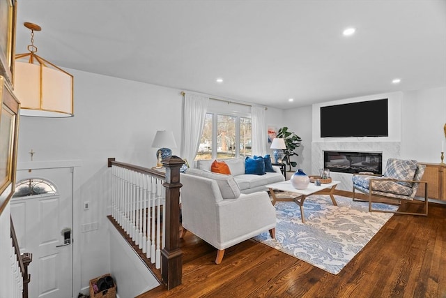 living room featuring recessed lighting, a fireplace, and dark wood-type flooring