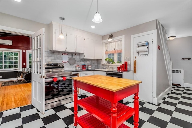 kitchen featuring radiator, butcher block counters, tile patterned floors, stainless steel electric stove, and white cabinetry