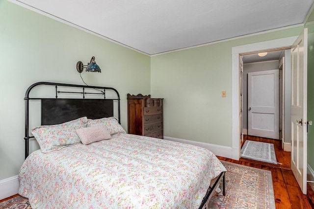 bedroom with baseboards and wood finished floors