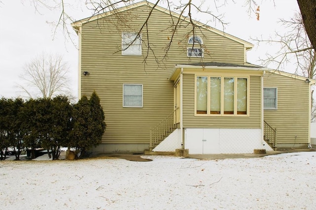 view of snow covered rear of property