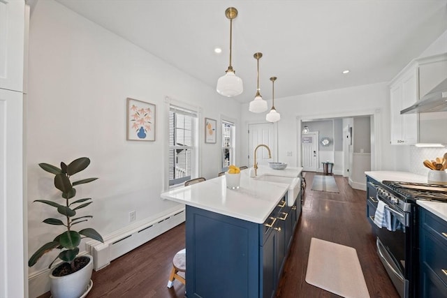 kitchen featuring blue cabinetry, stainless steel gas range oven, baseboard heating, and a sink