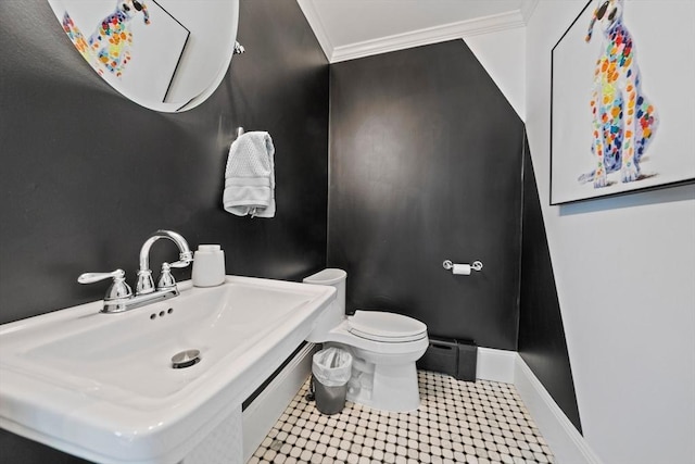 bathroom with a baseboard radiator, toilet, ornamental molding, a sink, and baseboards