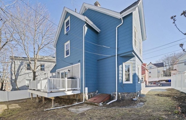 back of property featuring fence and a wooden deck