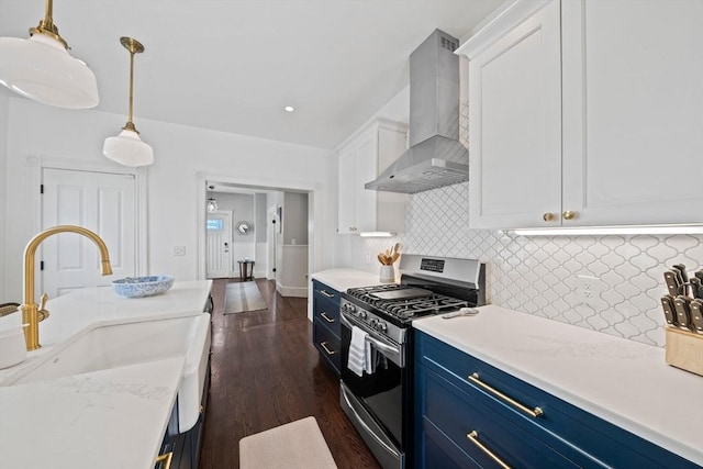 kitchen featuring a sink, white cabinetry, blue cabinetry, wall chimney exhaust hood, and gas stove