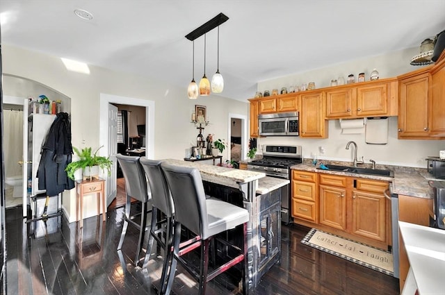 166 Beattie St Unit 2, Fall River, MA 02723 - kitchen featuring stainless steel appliances, a sink, decorative light fixtures, a breakfast bar, and dark wood-style floors