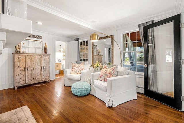 living area featuring a baseboard heating unit, ornamental molding, and hardwood / wood-style flooring