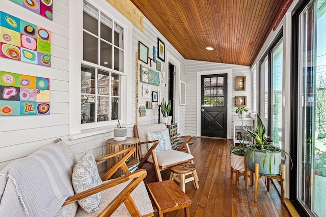 sunroom / solarium with wood-type flooring, wooden walls, and wooden ceiling