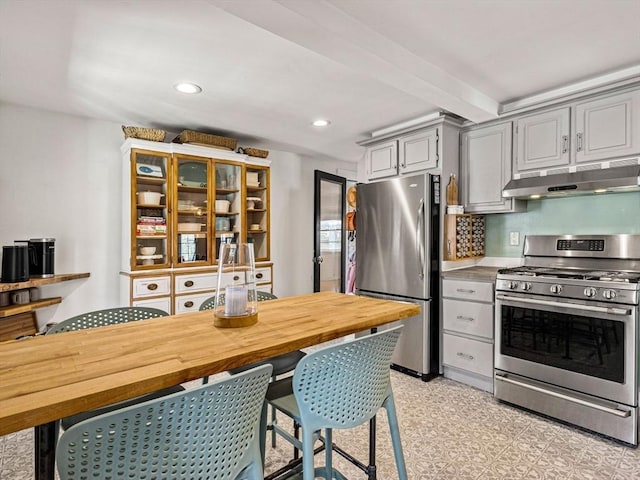 kitchen featuring appliances with stainless steel finishes, a breakfast bar area, gray cabinets, recessed lighting, and under cabinet range hood