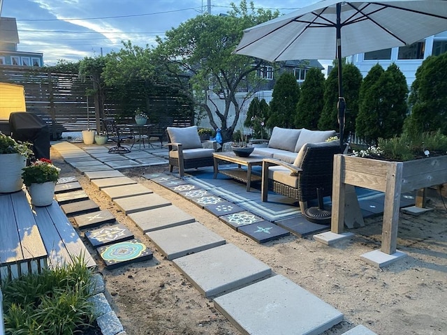 view of patio featuring fence, outdoor lounge area, and a wooden deck