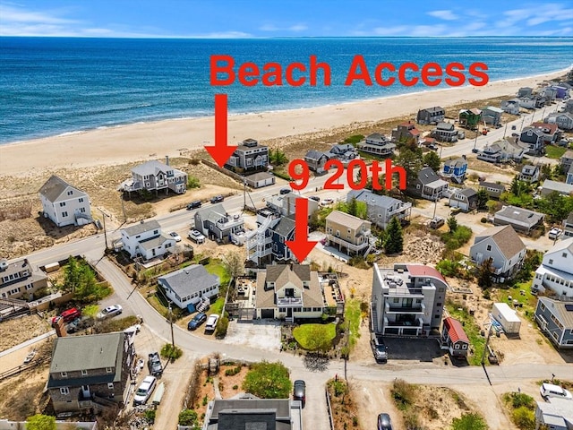 drone / aerial view featuring a water view and a beach view