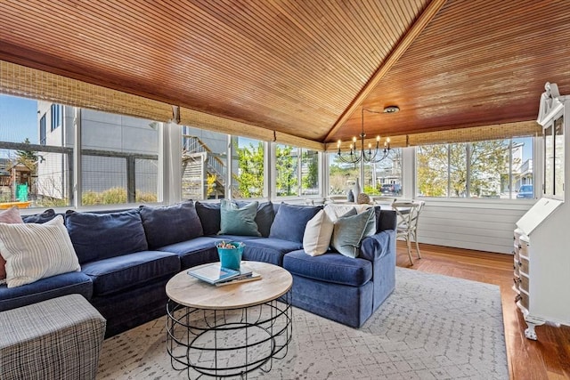 sunroom / solarium featuring vaulted ceiling, wood finished floors, a notable chandelier, and wooden ceiling