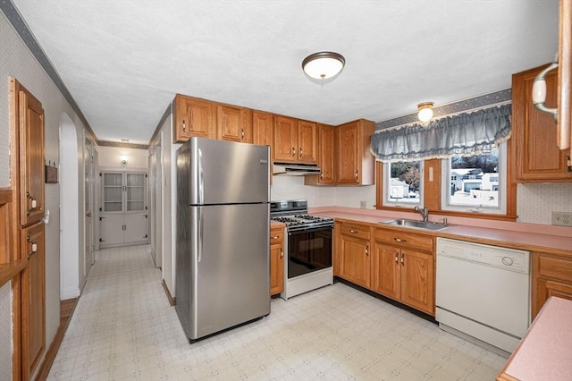 kitchen with gas stove, dishwasher, sink, and stainless steel refrigerator