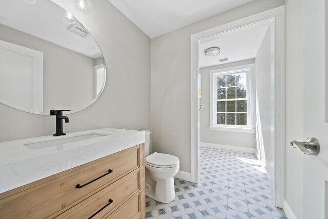 bathroom with tile patterned floors, visible vents, toilet, baseboards, and vanity