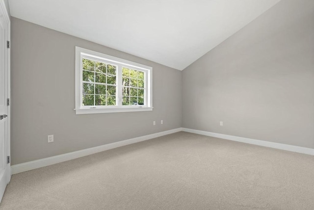 unfurnished room with baseboards, light carpet, and lofted ceiling