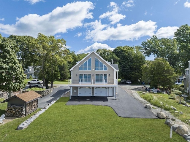 rear view of house featuring a lawn, a garage, and driveway