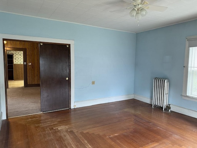 spare room with radiator, ceiling fan, and baseboards
