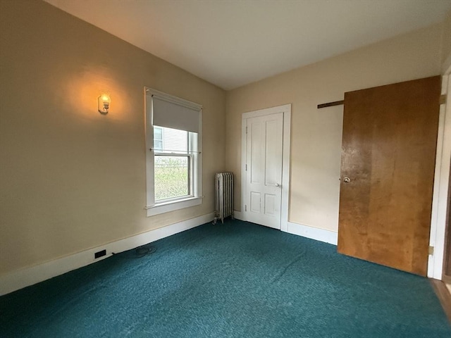 unfurnished bedroom featuring radiator heating unit, carpet flooring, and baseboards