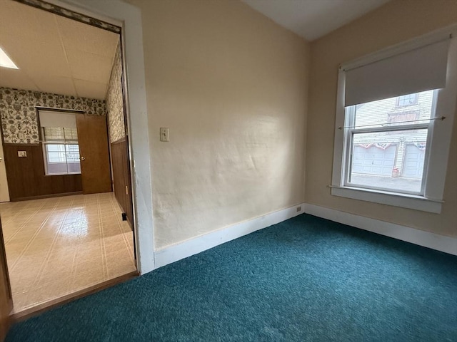 empty room with baseboards, wallpapered walls, and carpet