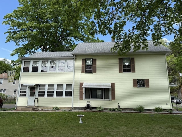 back of house with a lawn