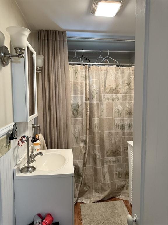 full bath with vanity, a shower with shower curtain, and wood finished floors