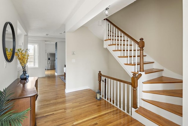 staircase with baseboards and wood finished floors