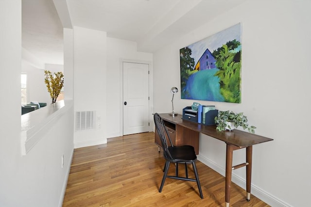 office area featuring visible vents, baseboards, arched walkways, and wood finished floors