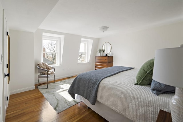 bedroom featuring wood finished floors and baseboards