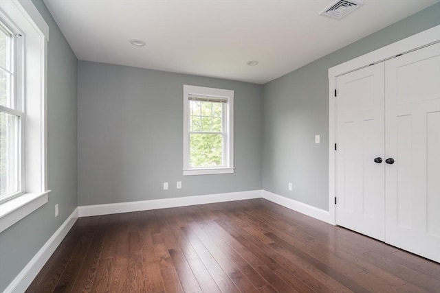 32 Charles St, Natick, MA 01760 - unfurnished bedroom with dark wood-style floors, baseboards, and a closet