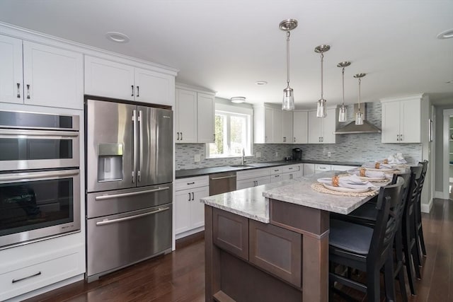 32 Charles St, Natick, MA 01760 - kitchen with stainless steel appliances, wall chimney range hood, dark wood-style floors, backsplash, and white cabinets