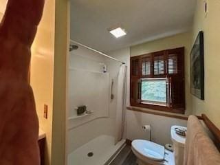 bathroom with toilet and a shower