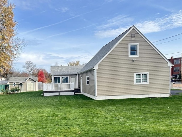 back of property with a lawn, a storage unit, and a wooden deck