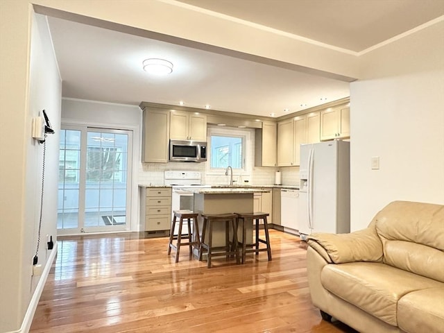 kitchen featuring backsplash, white appliances, a kitchen bar, gray cabinets, and ornamental molding