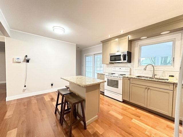 kitchen featuring light wood-type flooring, light stone counters, sink, white electric range, and a center island