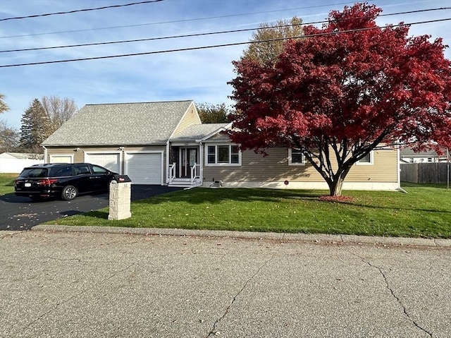 view of front of home with a front yard and a garage