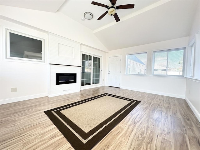 unfurnished living room with a fireplace, ceiling fan, hardwood / wood-style floors, and lofted ceiling