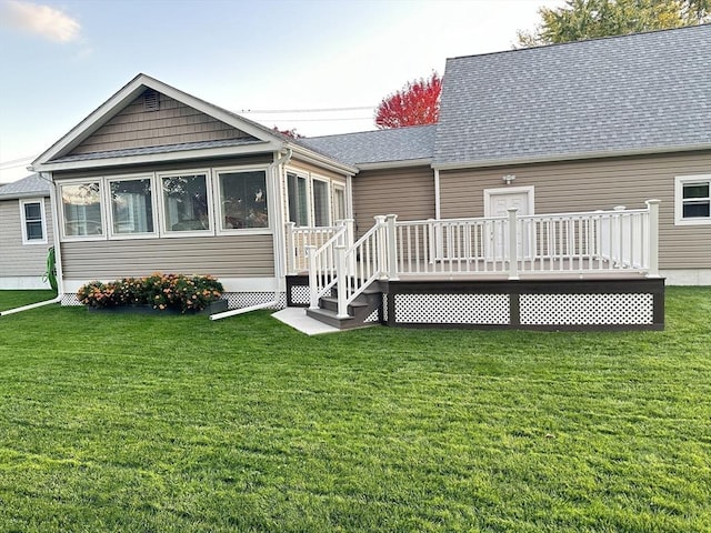 back of house with a sunroom, a yard, and a deck