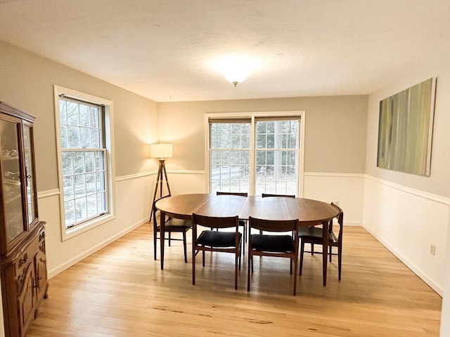 dining area featuring light wood-style floors and baseboards