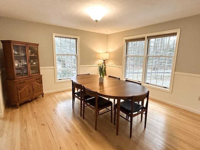 dining area with baseboards and light wood-style floors