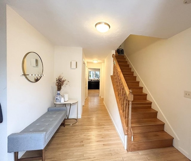 staircase featuring baseboards and wood finished floors