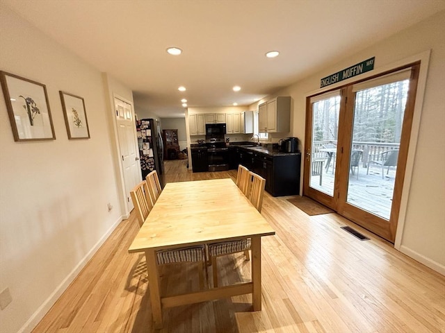 dining space with light wood-style flooring, baseboards, and visible vents