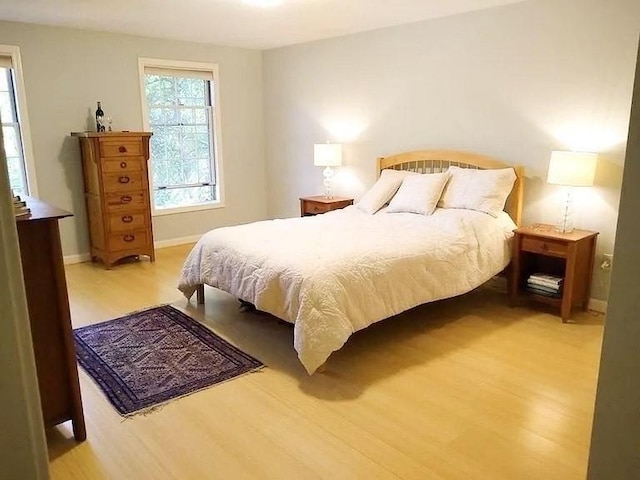 bedroom with light wood-type flooring and baseboards