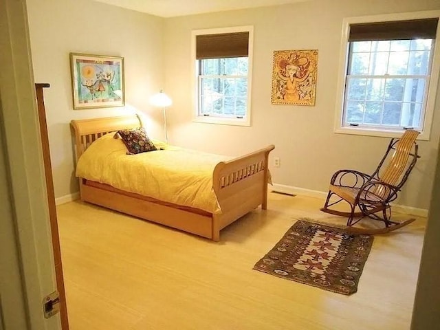 bedroom with baseboards and light wood-style flooring