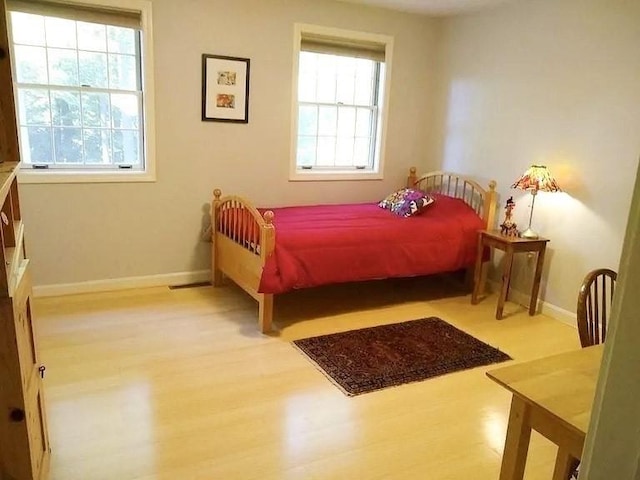 bedroom with baseboards and wood finished floors