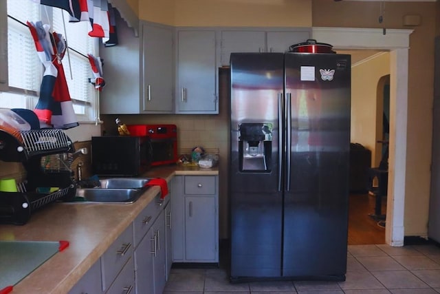 27 Bushwick Pl, Springfield, MA 01109 - kitchen with refrigerator with ice dispenser, a sink, light tile patterned floors, light countertops, and black microwave